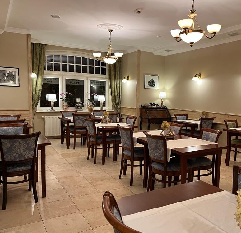 Eleganckie wnętrze restauracji La Spezia z klasycznymi krzesłami i żyrandolami